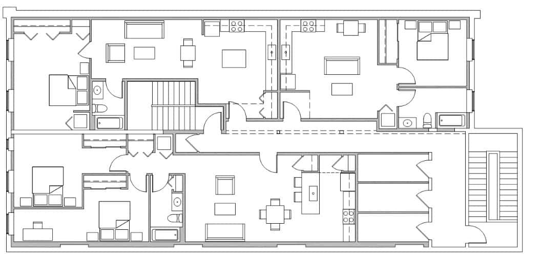 Black and white floor plan showing multiple rooms, including bedrooms, bathrooms, kitchens, living areas, and staircases arranged across two downtown Champaign loft apartments with adjoining commercial space.